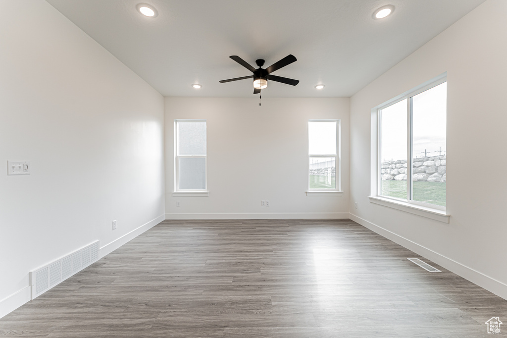 Empty room with a ceiling fan, recessed lighting, and wood finished floors