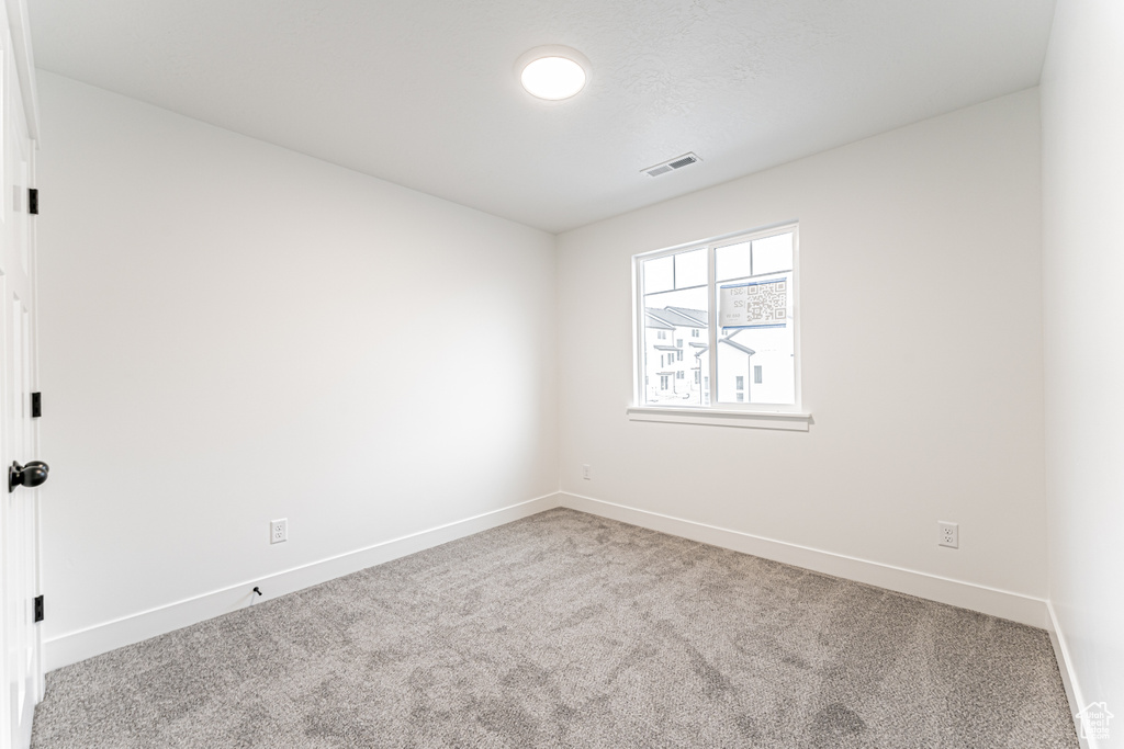 Carpeted empty room featuring baseboards
