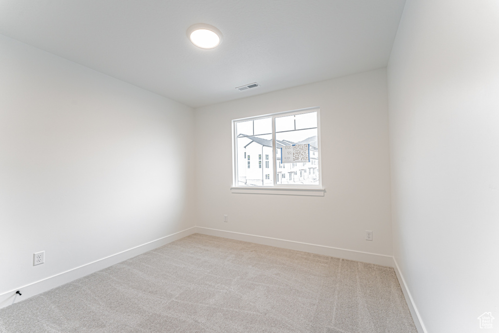 Carpeted spare room with baseboards