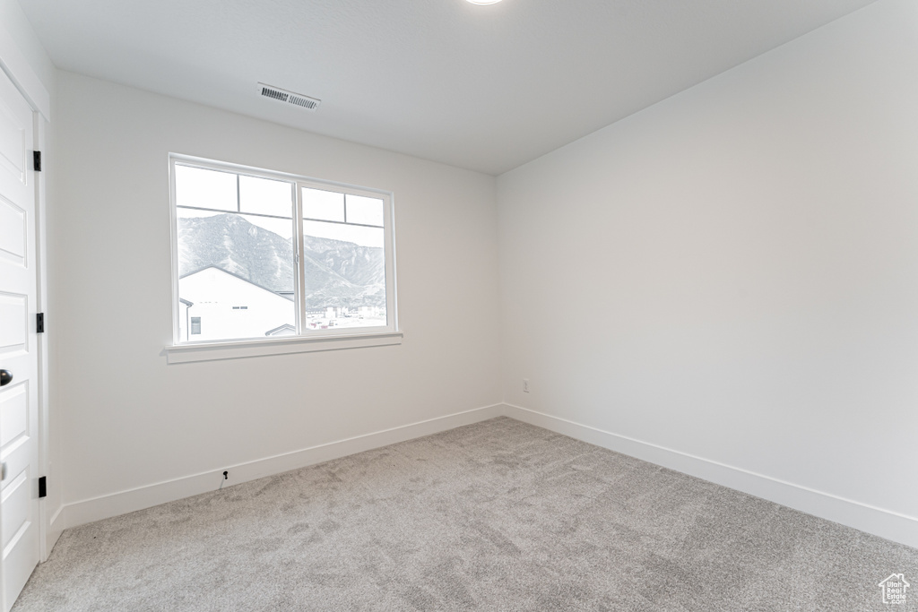 Unfurnished bedroom featuring carpet flooring and a mountain view