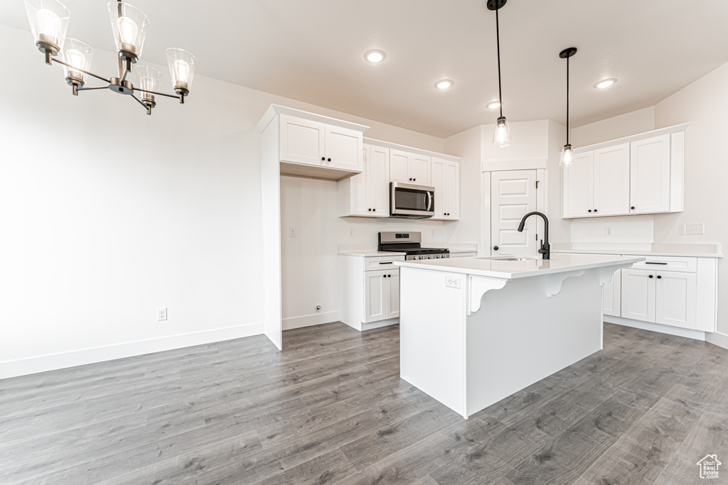 Kitchen featuring stainless steel appliances, light wood-type flooring, light countertops, white cabinetry, and recessed lighting