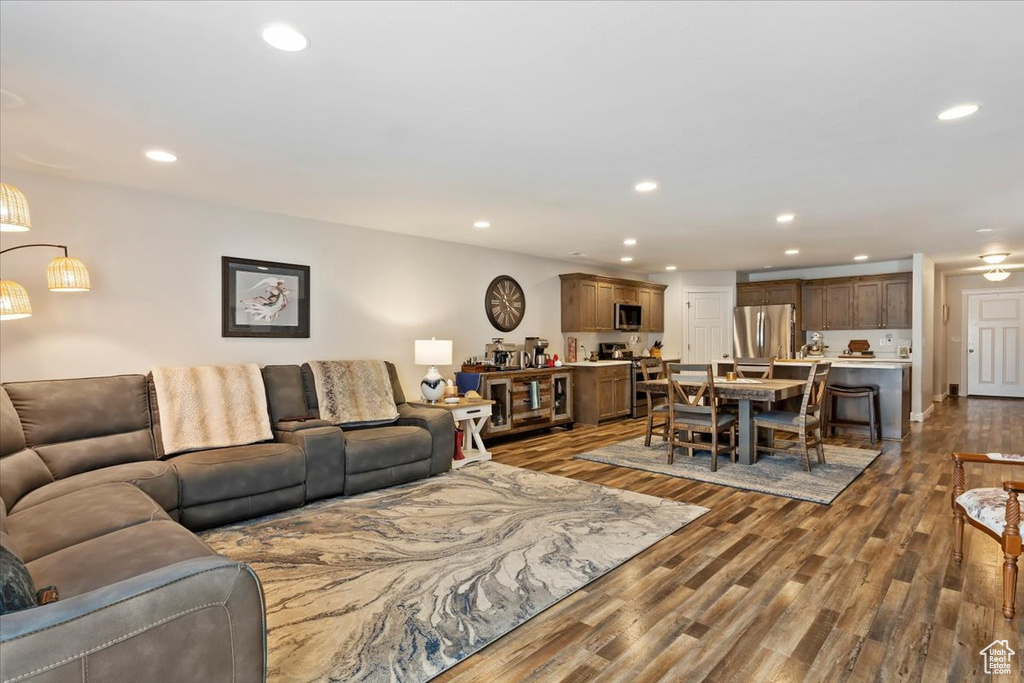Living area with recessed lighting and dark wood-style flooring