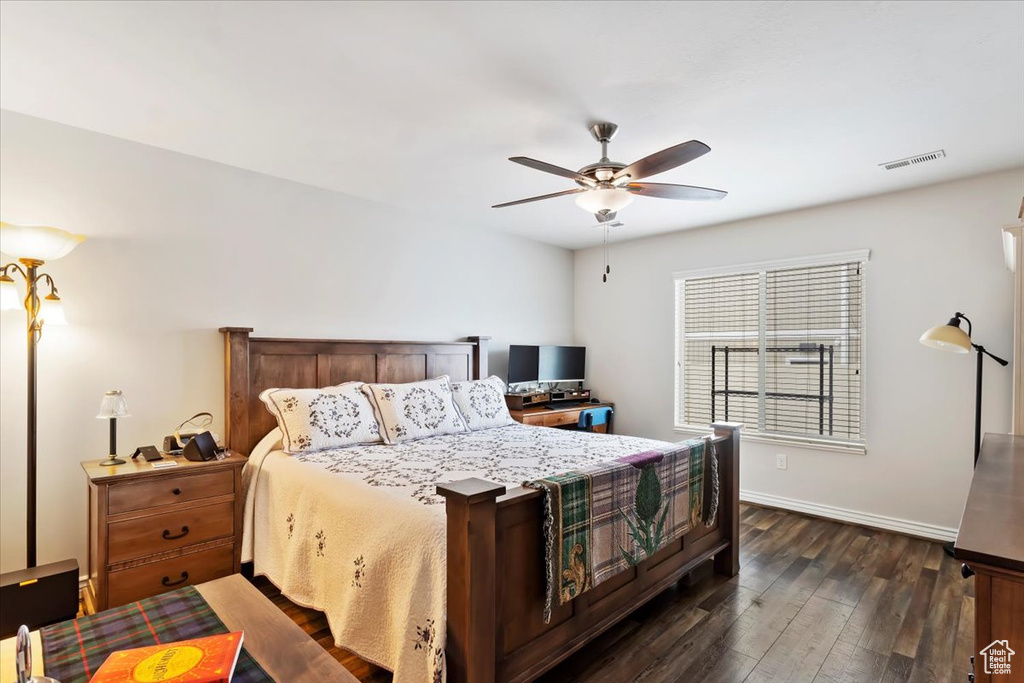 Bedroom featuring ceiling fan, visible vents, baseboards, and dark wood finished floors