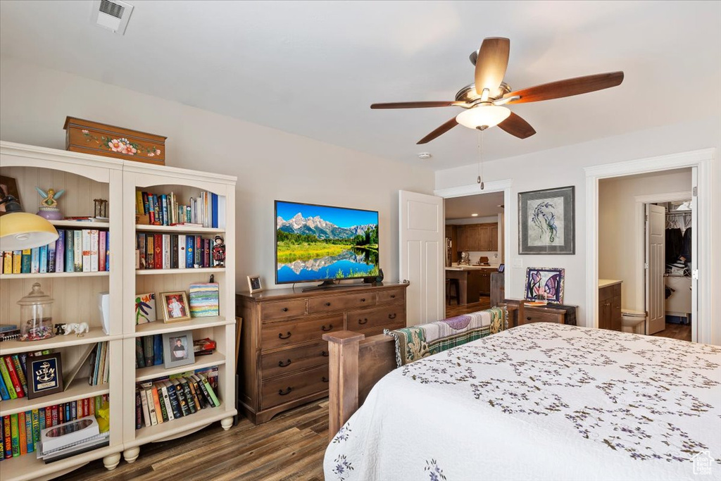 Bedroom with a ceiling fan, wood finished floors, visible vents, and connected bathroom