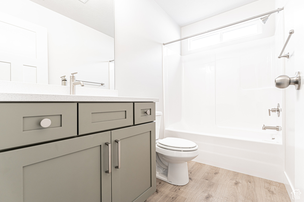 Full bathroom with vanity, shower / washtub combination, and wood finished floors