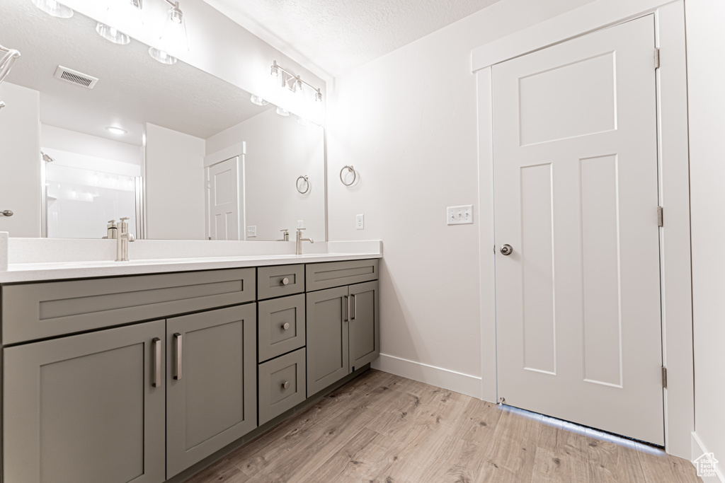 Bathroom with double vanity and wood finished floors