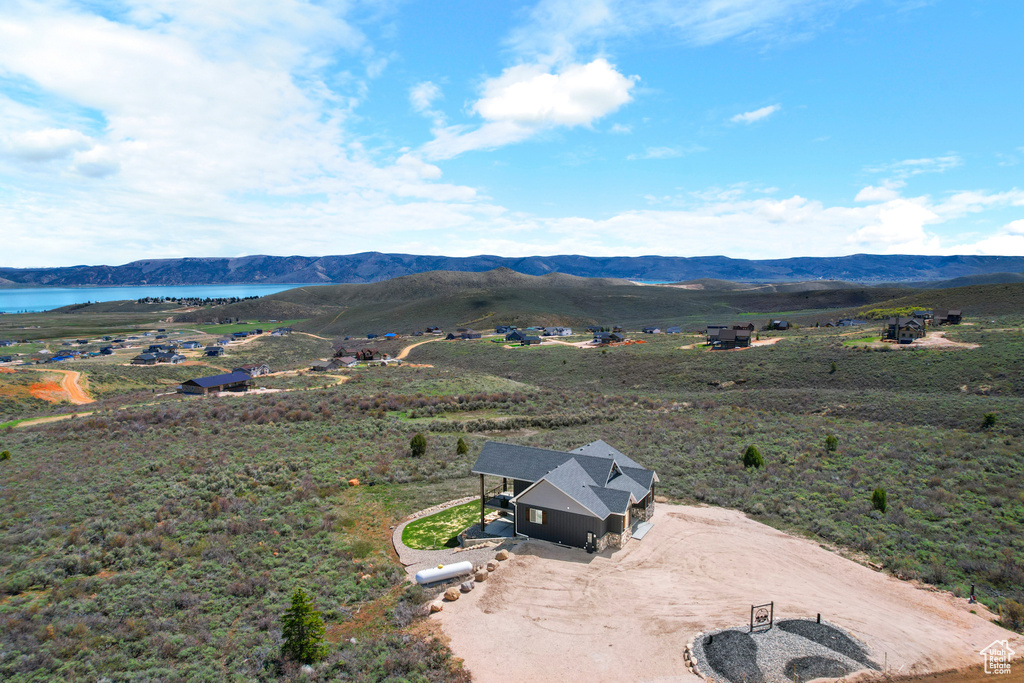 Aerial view of property and surrounding area with a water and mountain view