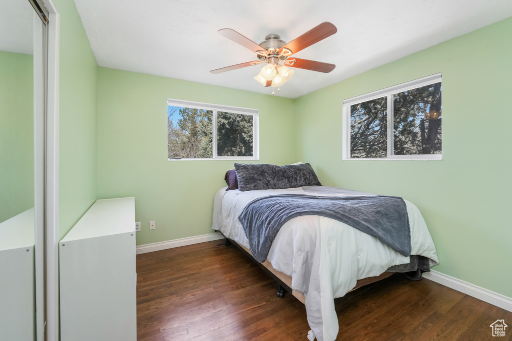 Bedroom with a ceiling fan, wood finished floors, and baseboards