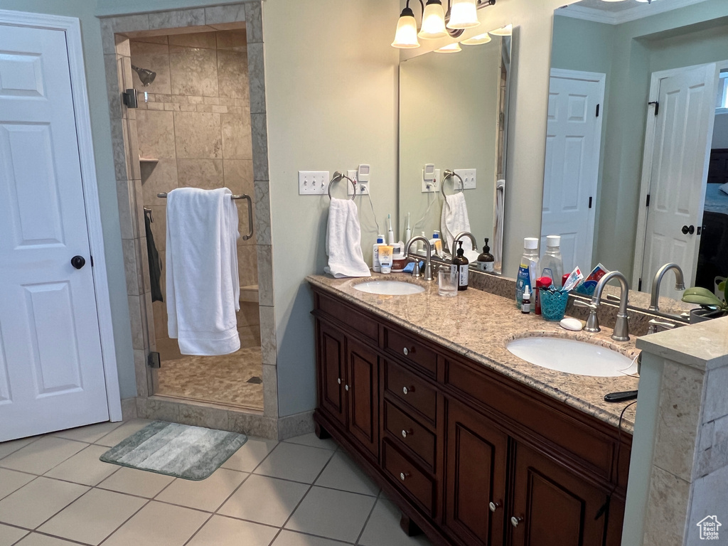 Bathroom with double vanity, a stall shower, and a sink