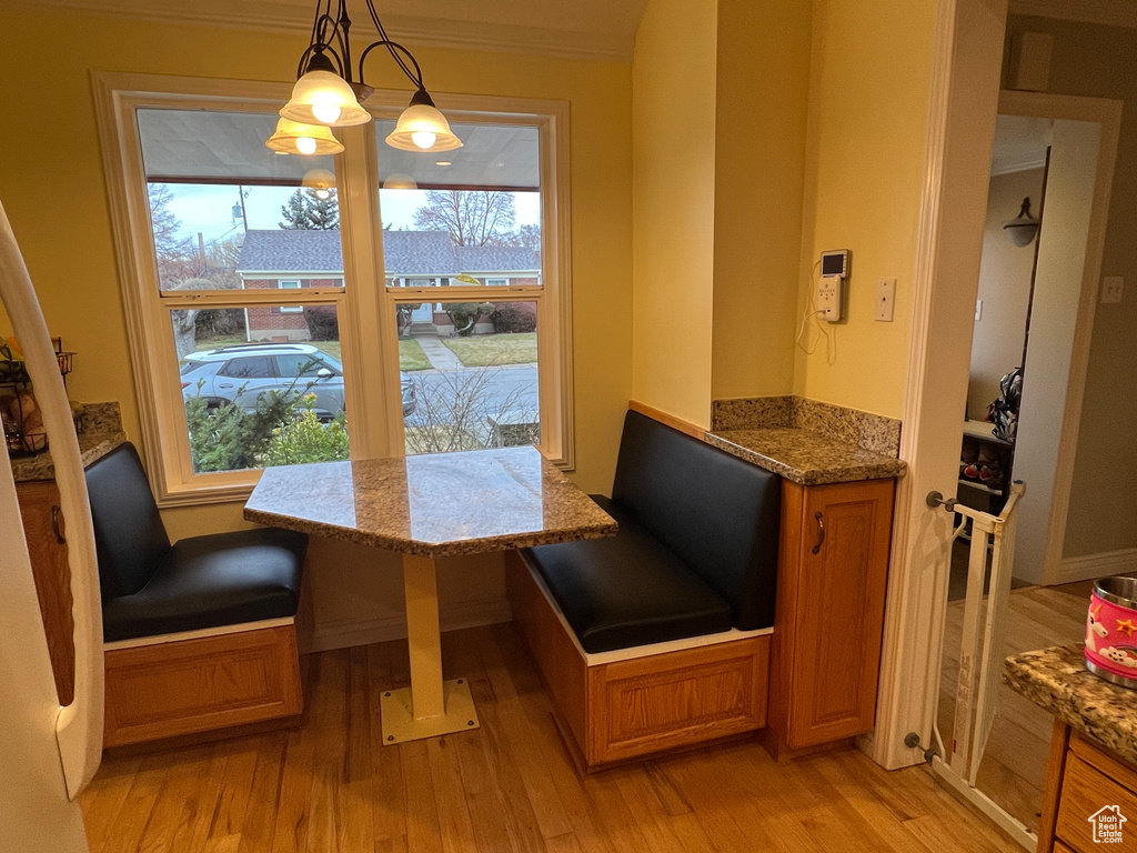 Dining area featuring crown molding, a notable chandelier, light wood finished floors, and breakfast area