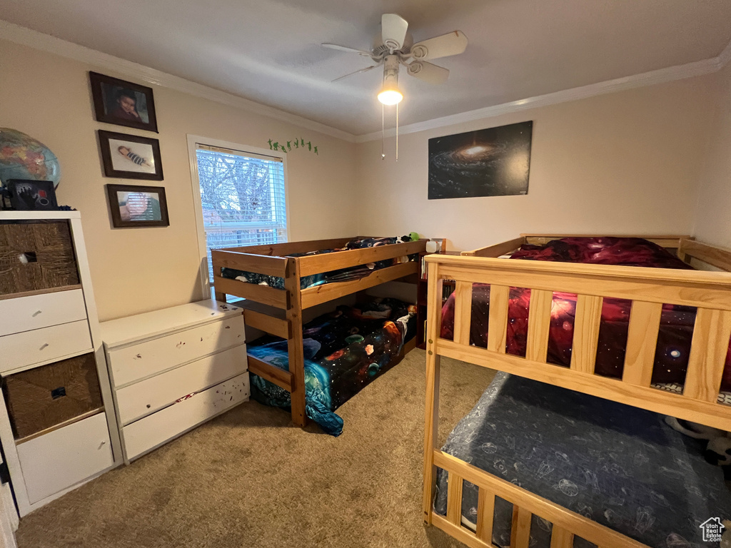 Bedroom with ceiling fan, carpet floors, and ornamental molding