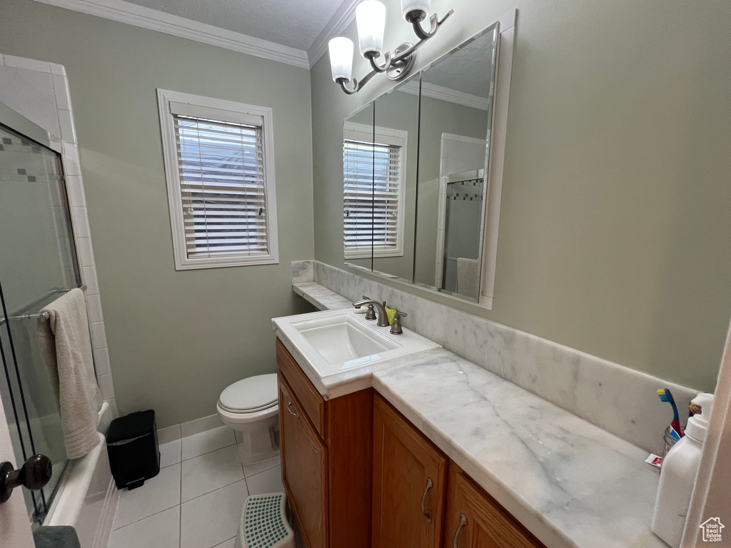 Bathroom featuring vanity, crown molding, toilet, tile patterned floors, and a chandelier