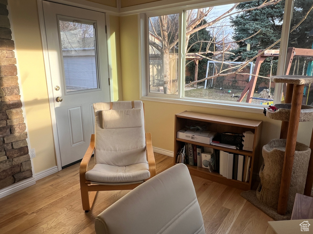 Living area with a healthy amount of sunlight, baseboards, and wood finished floors