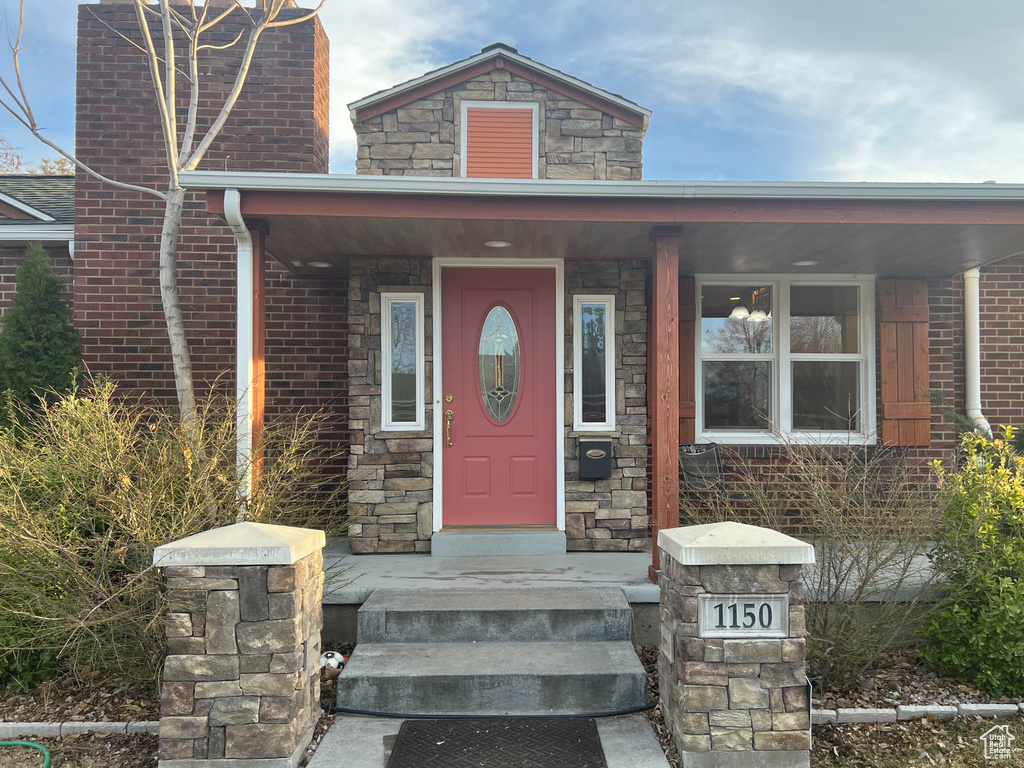 View of exterior entry with brick siding and stone siding