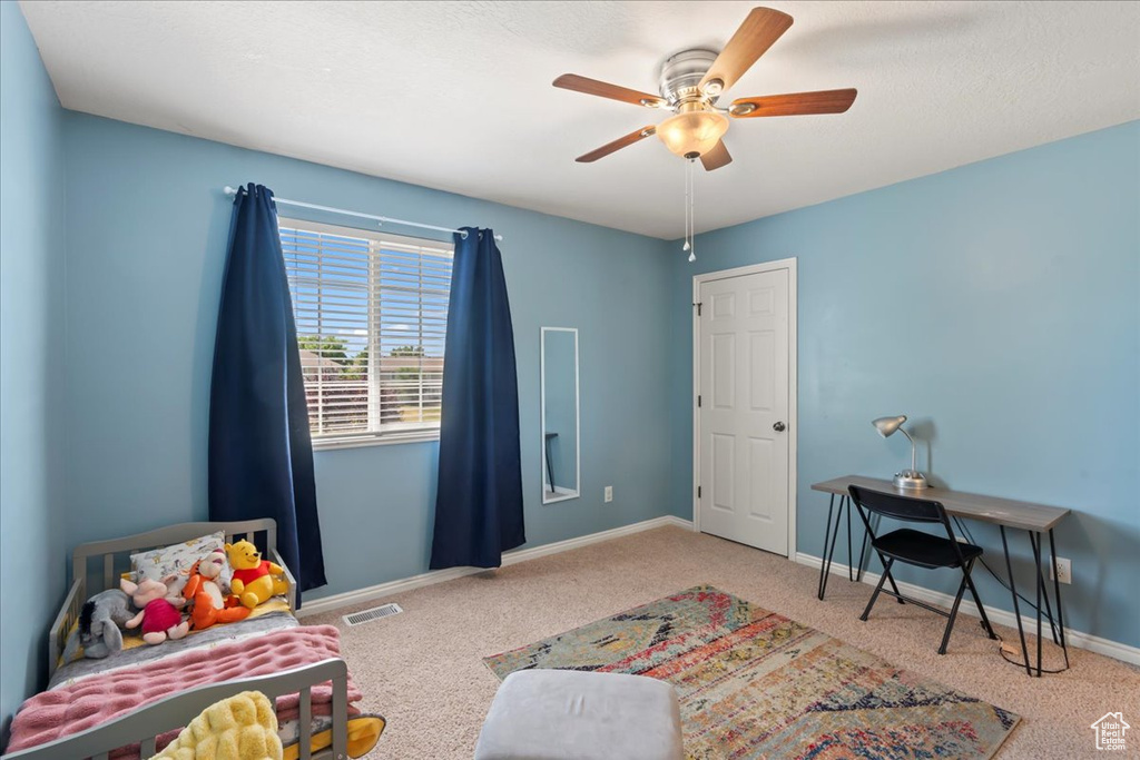 Carpeted bedroom with baseboards, visible vents, and ceiling fan