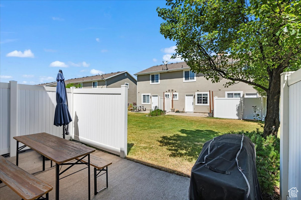 Back of property featuring a yard, a fenced backyard, stucco siding, and a patio