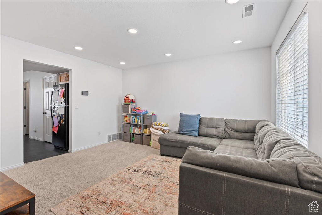 Living room featuring dark colored carpet and recessed lighting