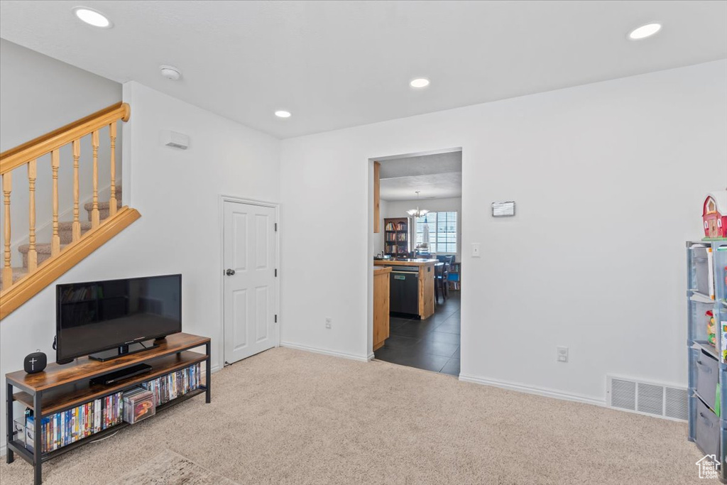 Living area with stairway, carpet flooring, recessed lighting, and a chandelier