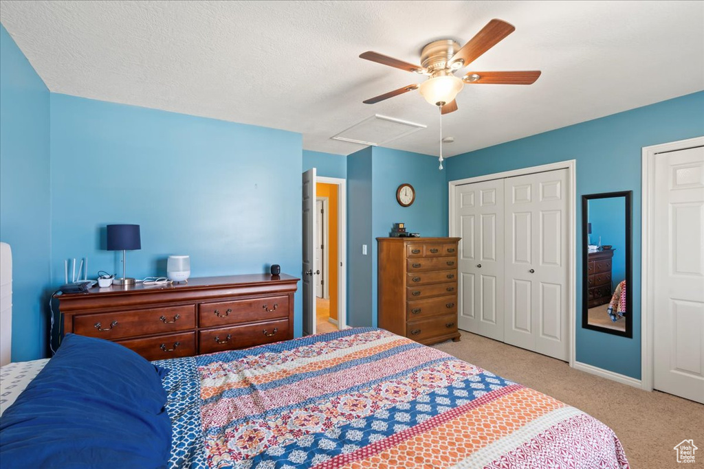 Bedroom with multiple closets, carpet flooring, a textured ceiling, and a ceiling fan