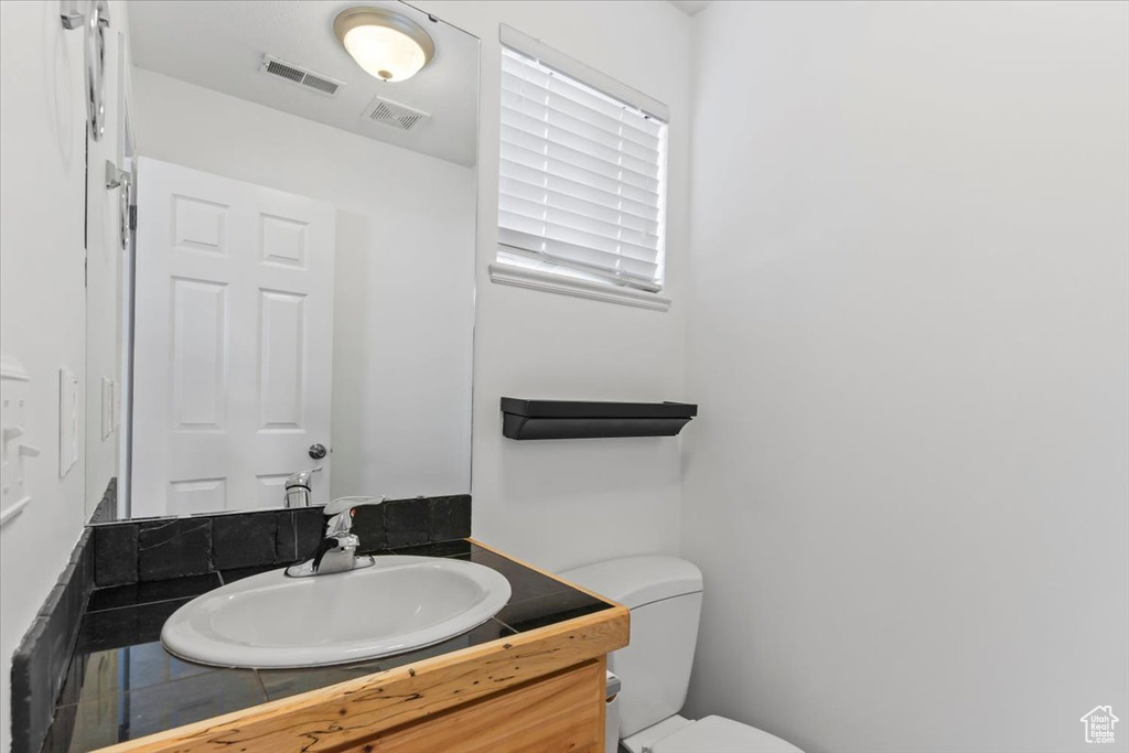 Half bath featuring vanity and toilet