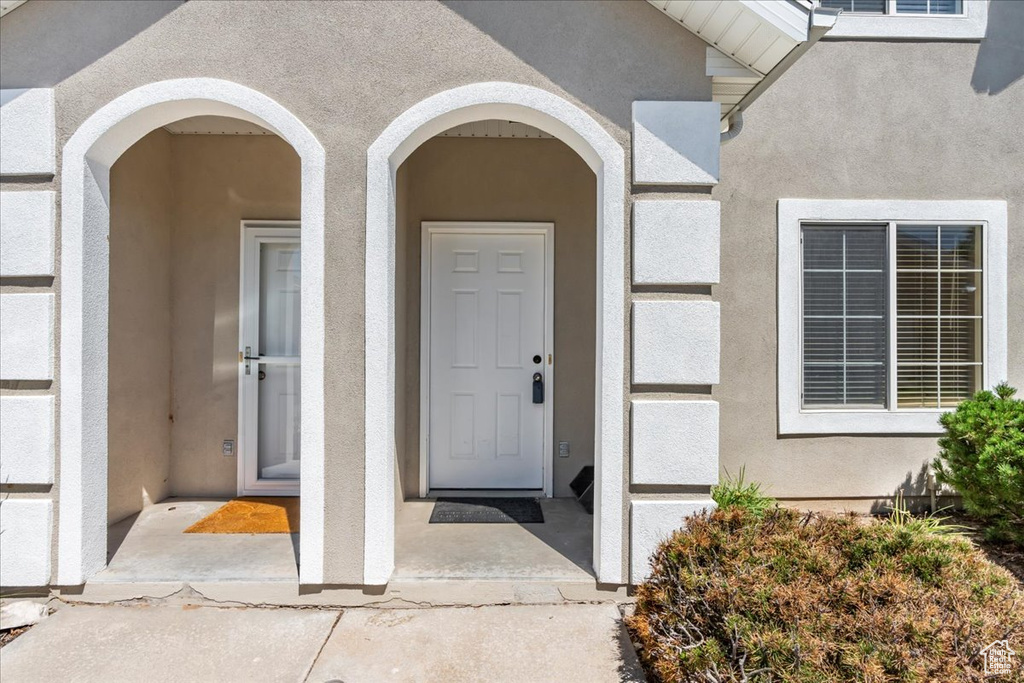 Entrance to property with stucco siding