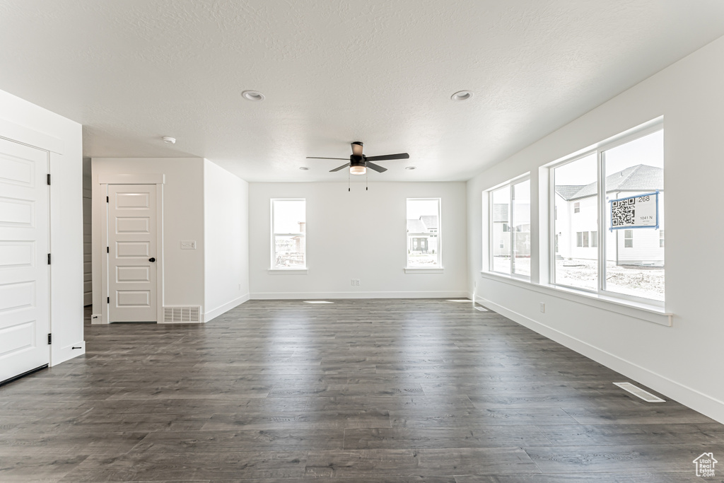 Empty room featuring a ceiling fan, dark wood-style flooring, and recessed lighting