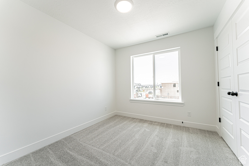 Unfurnished bedroom with light colored carpet
