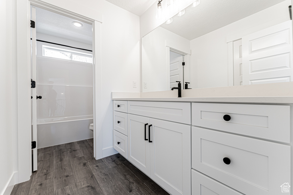 Bathroom featuring vanity, wood finished floors, and bathtub / shower combination