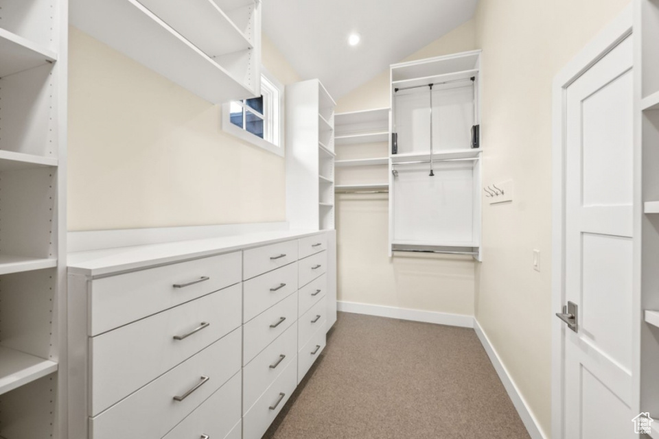 Walk in closet with carpet flooring and vaulted ceiling