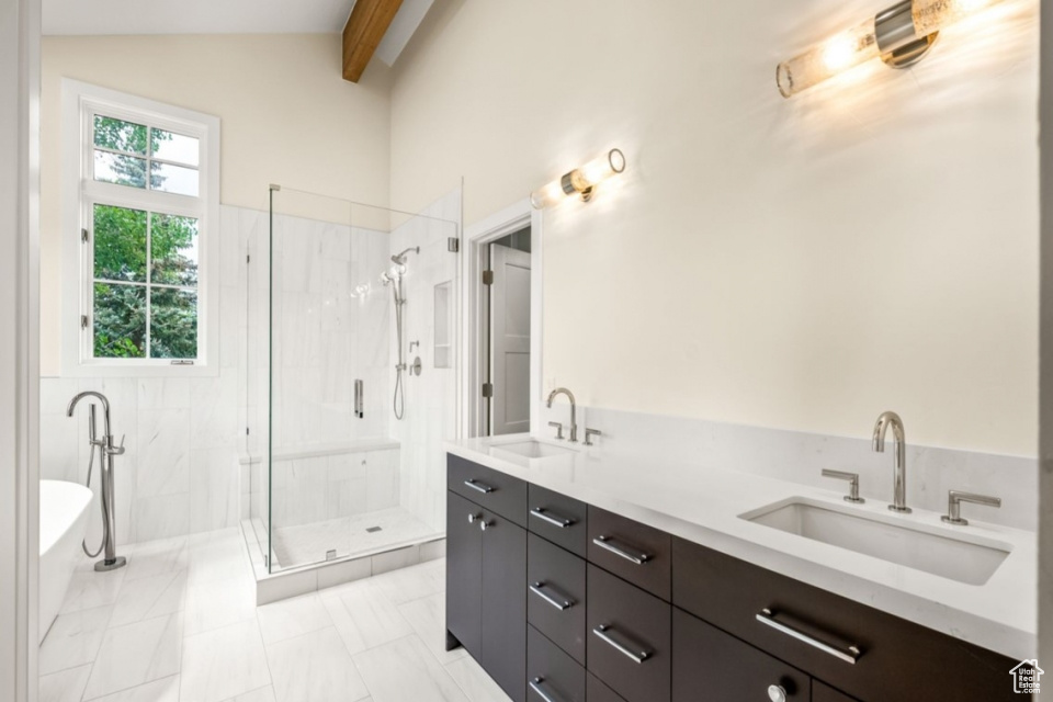 Bathroom with a freestanding bath, a stall shower, vaulted ceiling with beams, and a sink