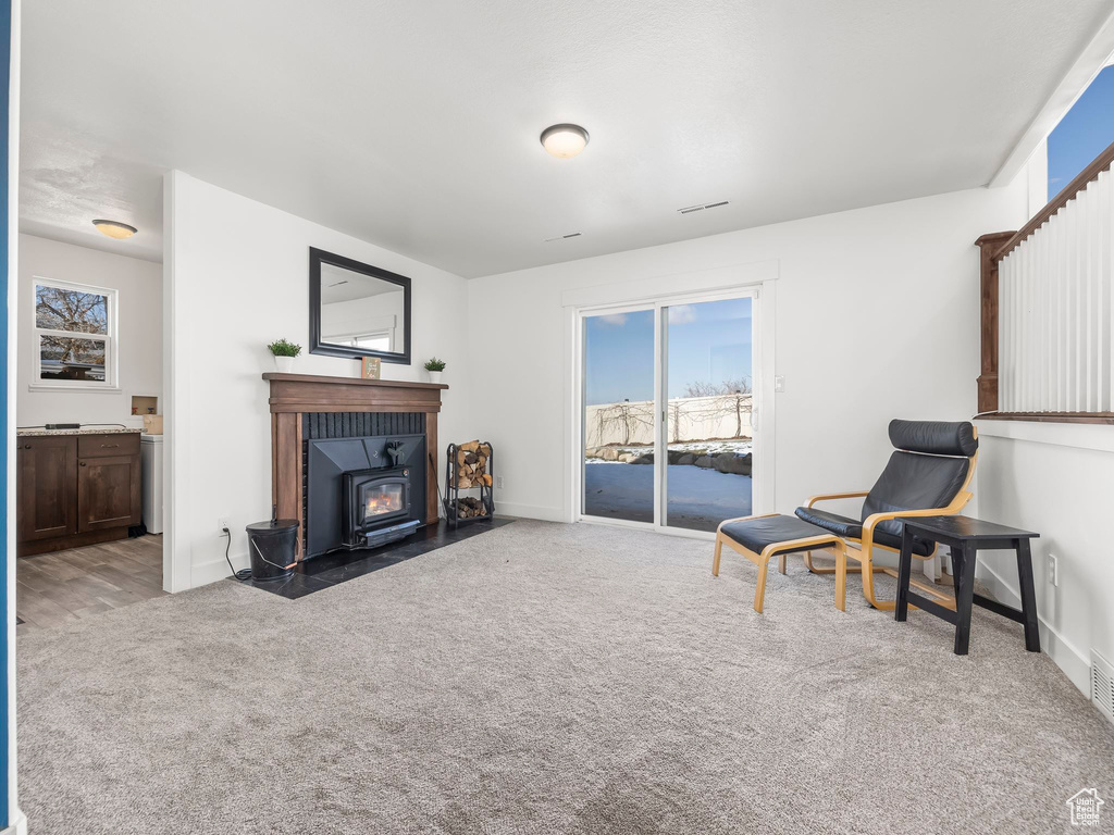 Sitting room with carpet flooring, visible vents, and baseboards