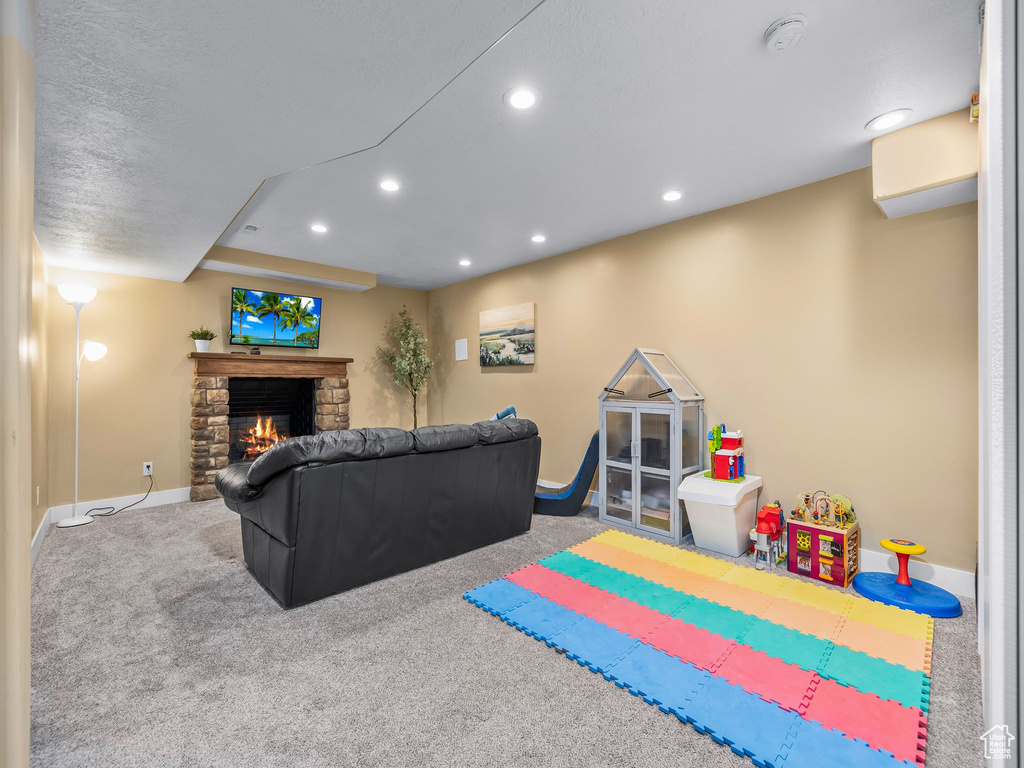 Rec room with a stone fireplace, recessed lighting, carpet, and baseboards