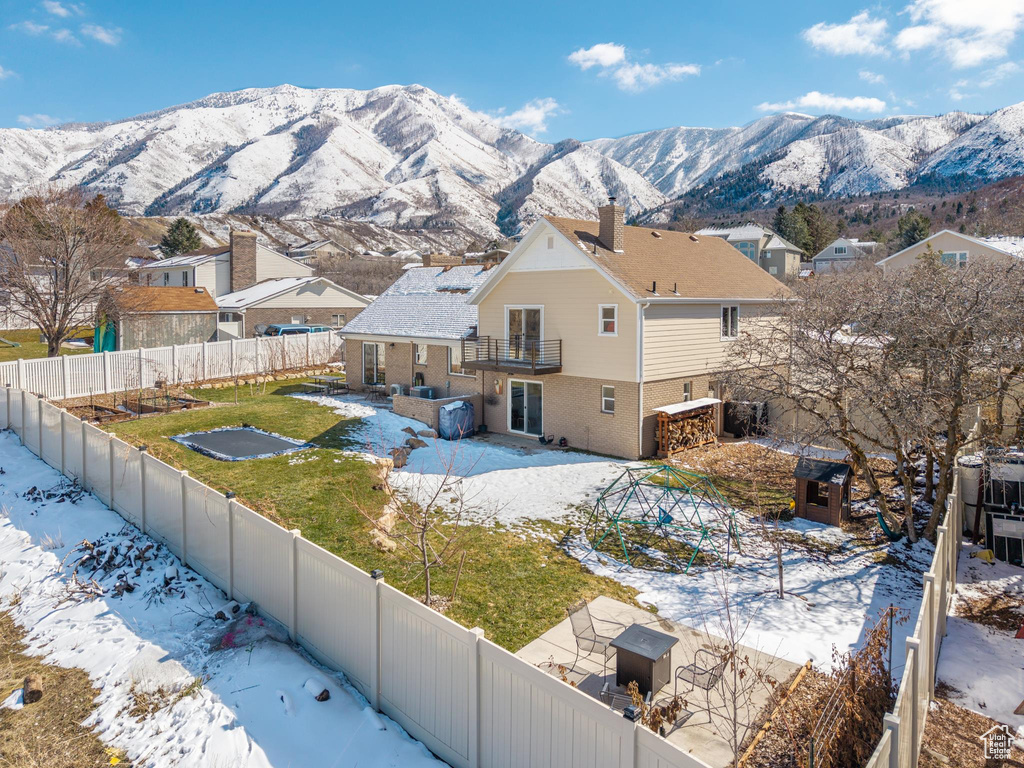 Exterior space featuring a mountain view, a fenced backyard, and brick siding