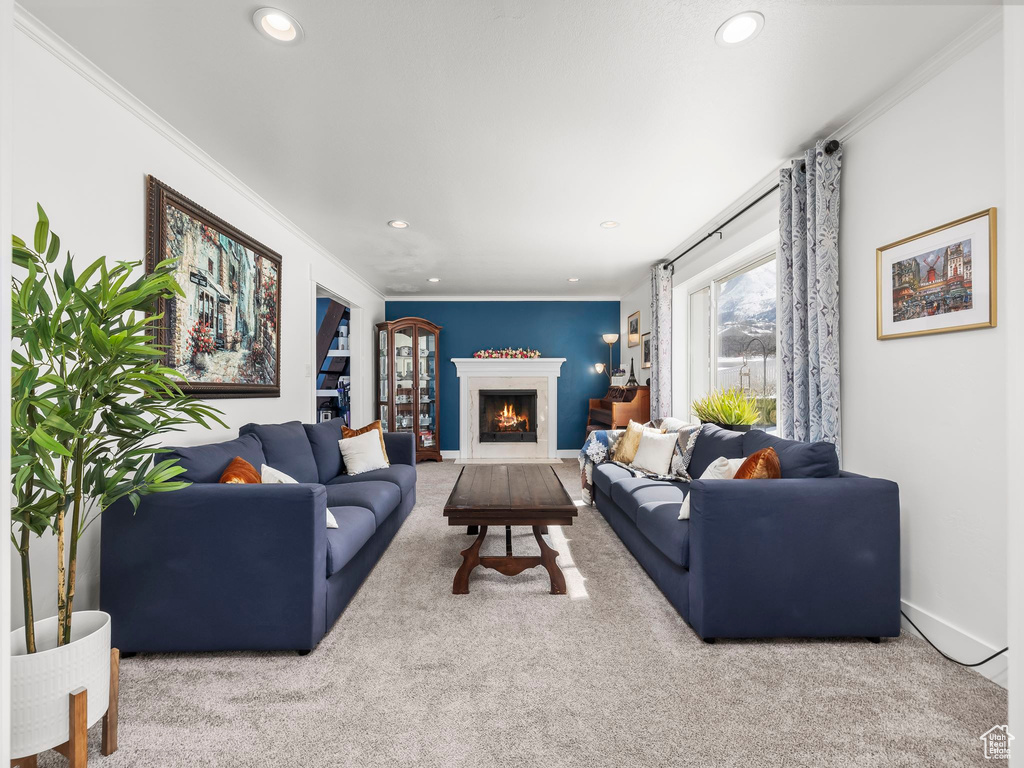 Carpeted living area featuring recessed lighting, baseboards, a warm lit fireplace, and crown molding