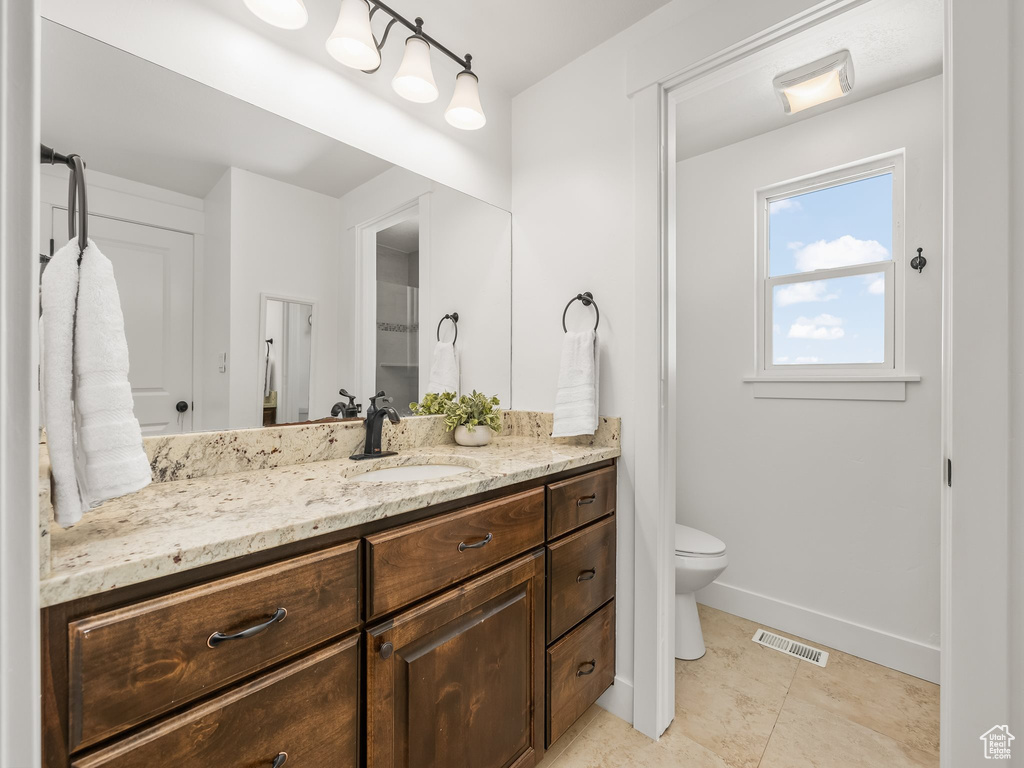 Bathroom with visible vents, baseboards, toilet, and vanity