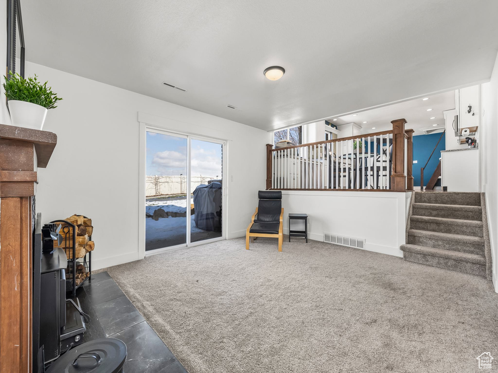 Carpeted living room with visible vents, recessed lighting, stairs, and baseboards