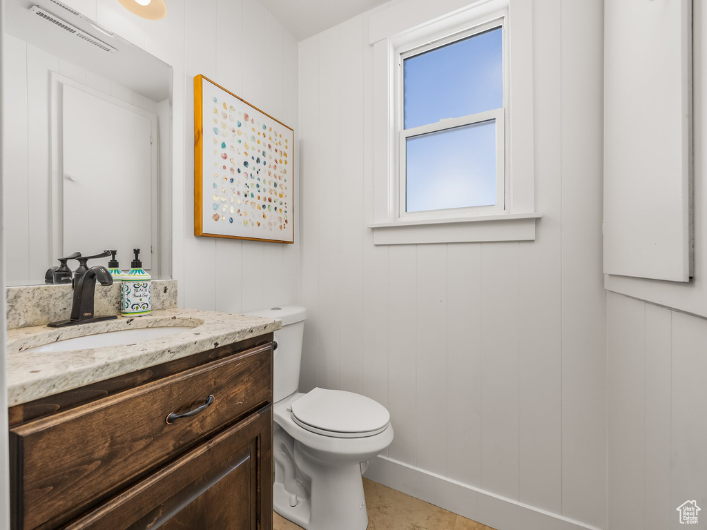 Half bath featuring vanity, toilet, and visible vents