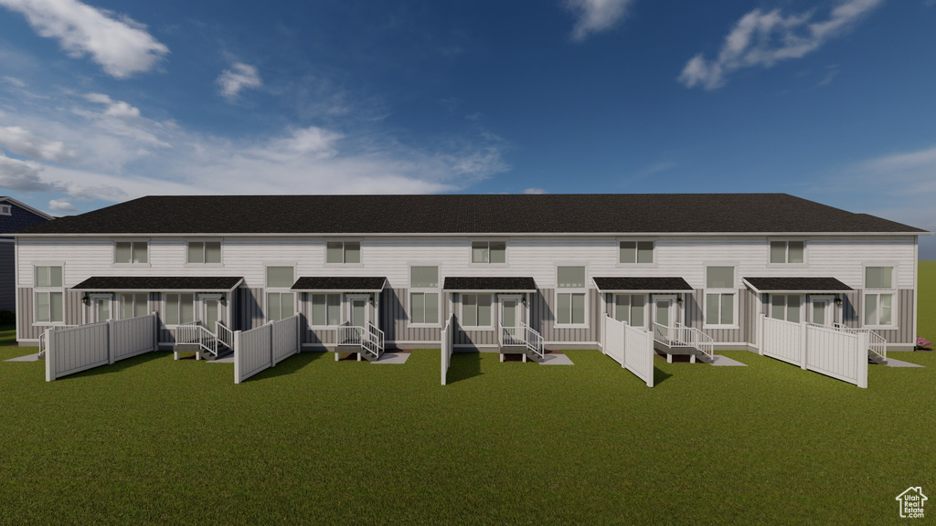Back of property featuring a wooden deck and a lawn