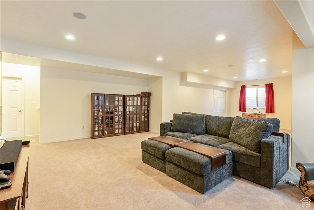 Living area with light carpet, recessed lighting, and baseboards