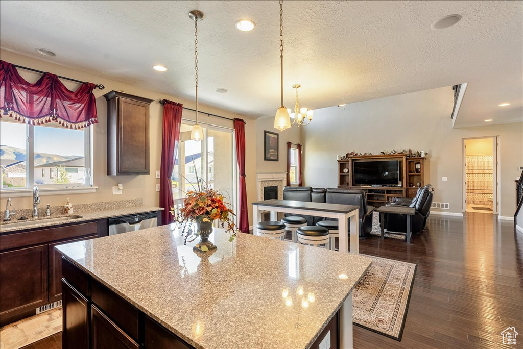 Kitchen with a sink, stainless steel dishwasher, healthy amount of natural light, light stone countertops, and recessed lighting