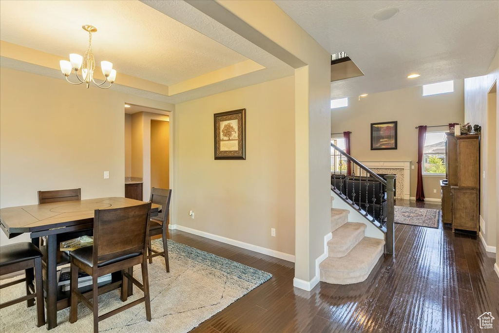 Dining room featuring a chandelier, hardwood / wood-style flooring, baseboards, stairs, and recessed lighting