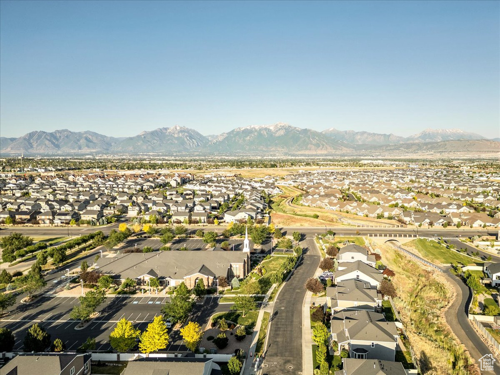 Aerial view of property and surrounding area with nearby suburban area and mountains