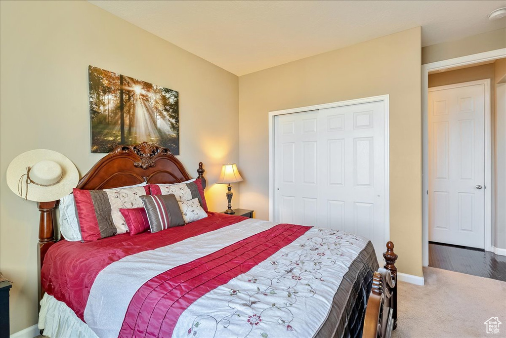 Bedroom with carpet, baseboards, and a closet