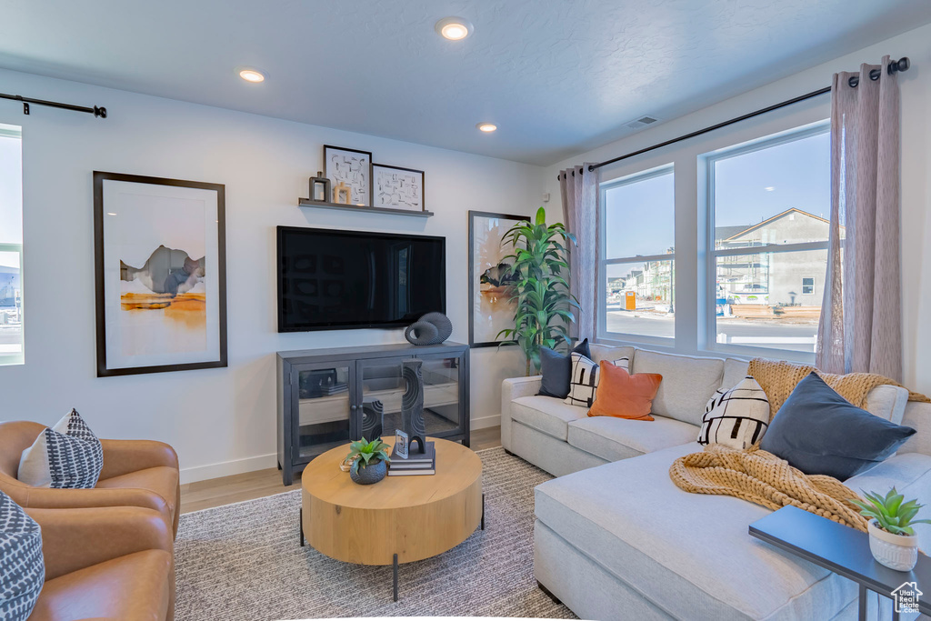 Living area with baseboards, wood finished floors, and recessed lighting