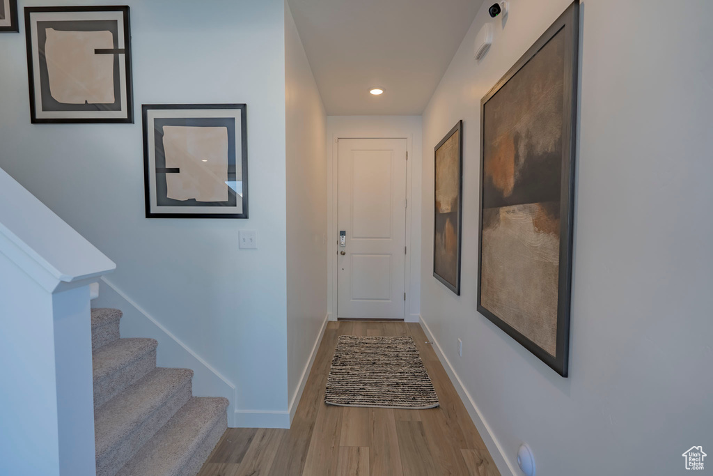 Corridor with stairway, recessed lighting, wood finished floors, and baseboards