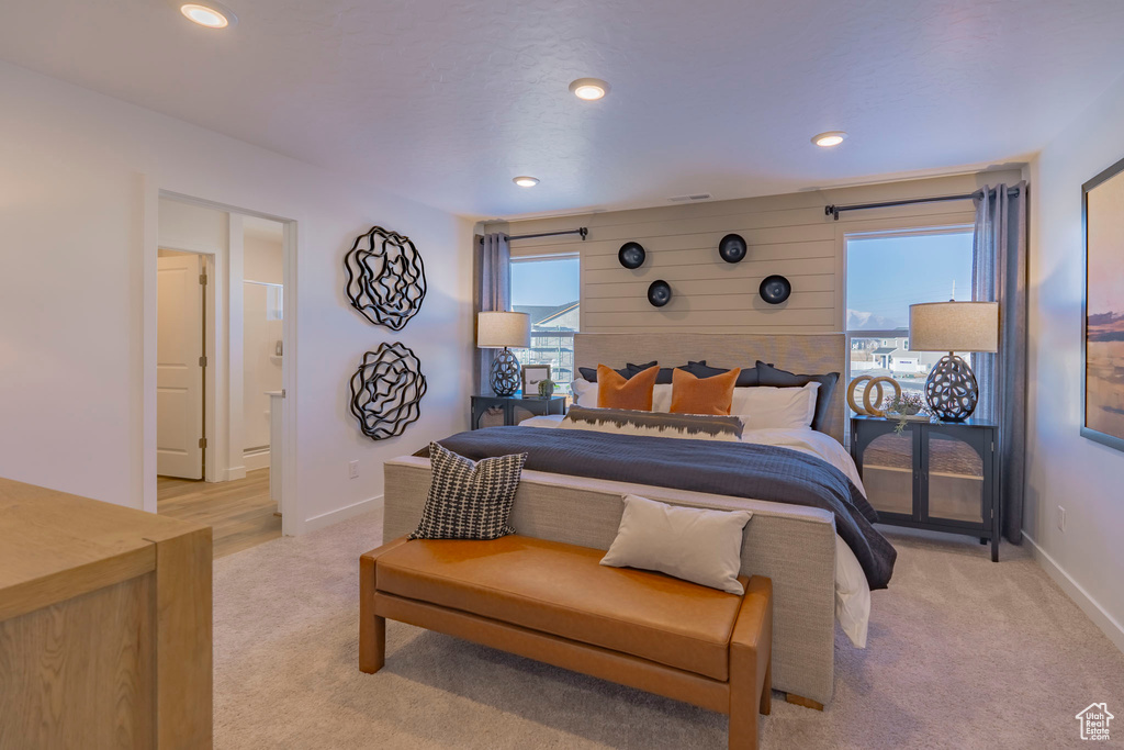Bedroom with recessed lighting, light colored carpet, baseboards, and multiple windows