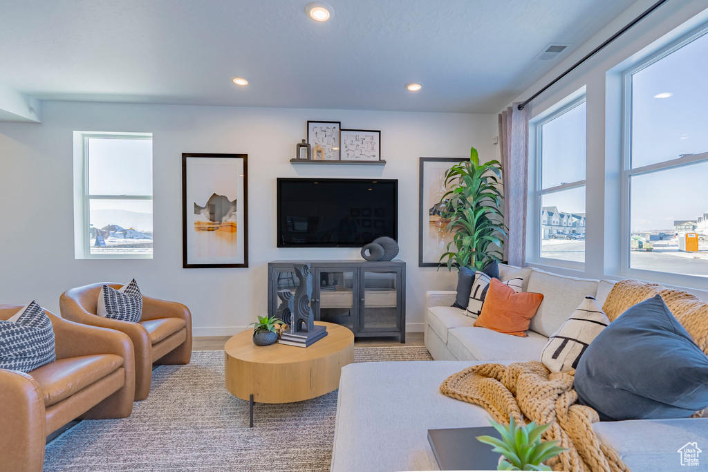 Living area featuring recessed lighting, visible vents, baseboards, and wood finished floors