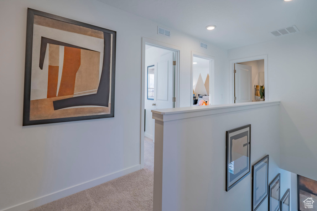 Hall featuring carpet, visible vents, and baseboards