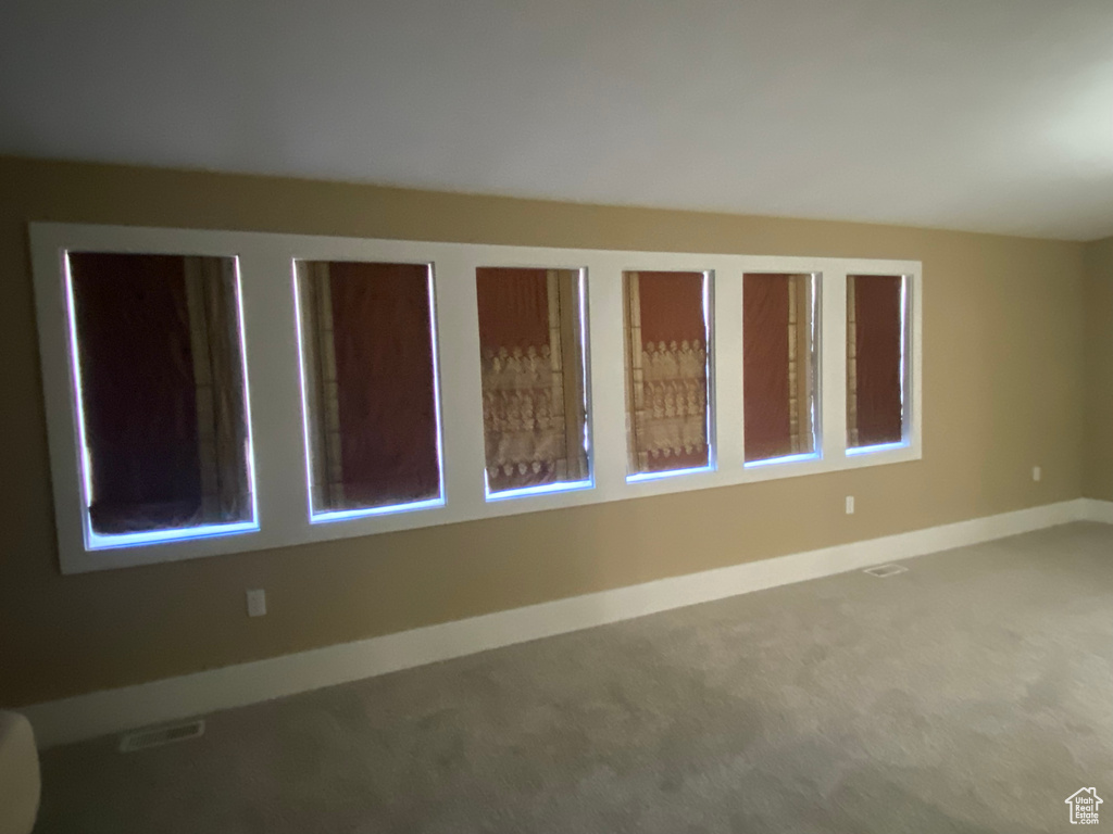 Carpeted spare room featuring visible vents and baseboards