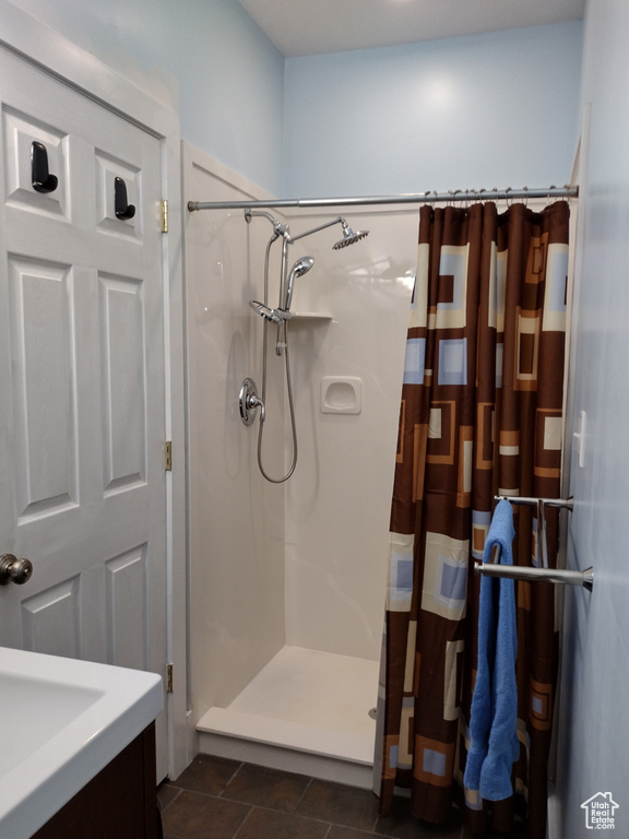 Bathroom with tile patterned floors, a stall shower, and vanity